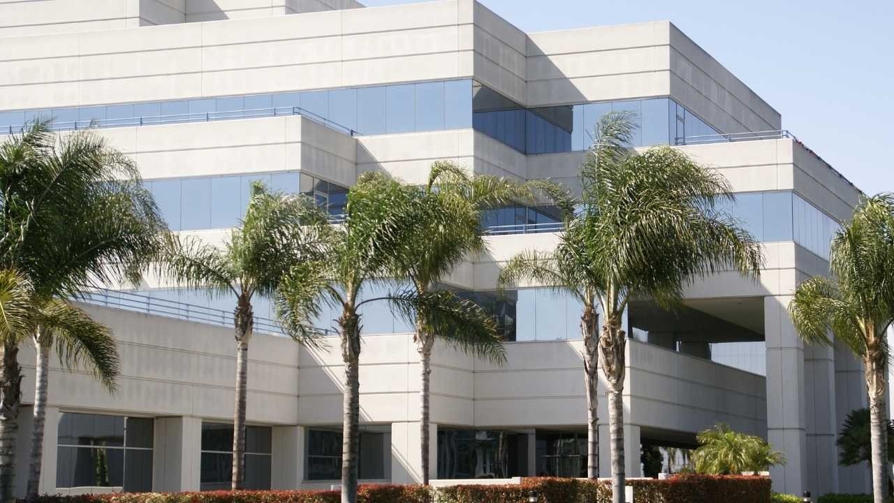 A large office building with palm trees